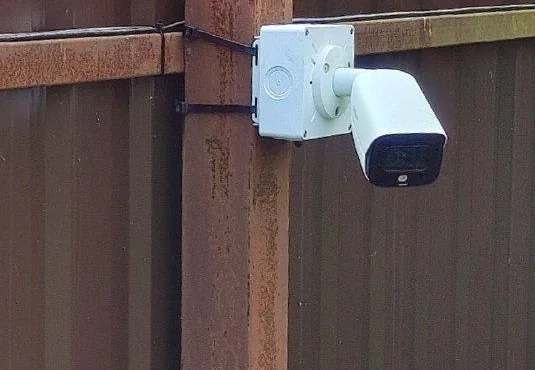 Коробка BOXFORCAM™ MONO LITE с камерой на угловом столбе забора, видна крышка-десятилистник