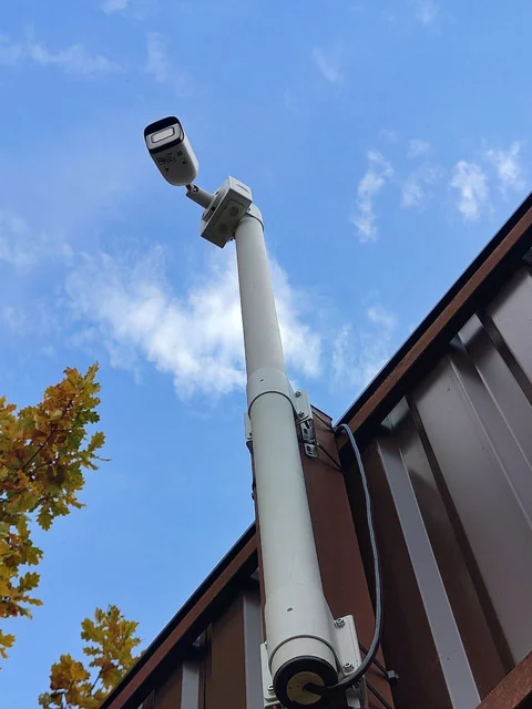 Камера на коробке BOXFORCAM™ MONO на трубостойке над забором из профлиста